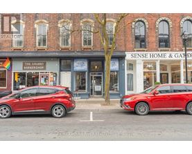 Two red cars are parked in front of a building with a sign that says "Sense Home & Garden".