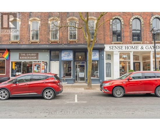 Two red cars are parked in front of a building with a sign that says "Sense Home & Garden".