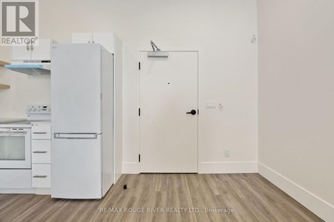 A white refrigerator and oven in a kitchen with a white door.