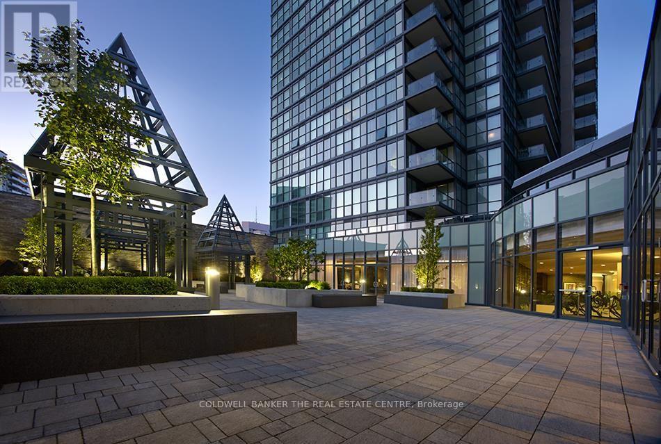 A modern building with glass windows and a tree in front of it.