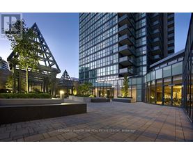A modern building with glass windows and a tree in front of it.