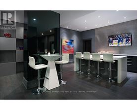 A modern bar area with a glass table and white chairs.