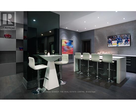 A modern bar area with a glass table and white chairs.