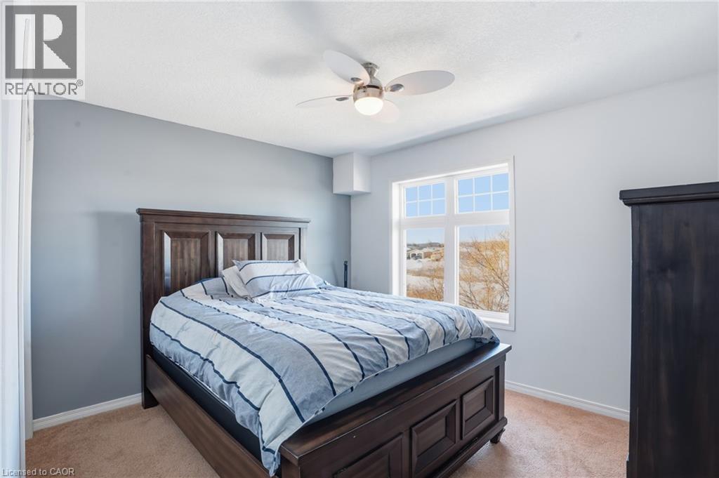 A bedroom with a large bed and a window overlooking a field.