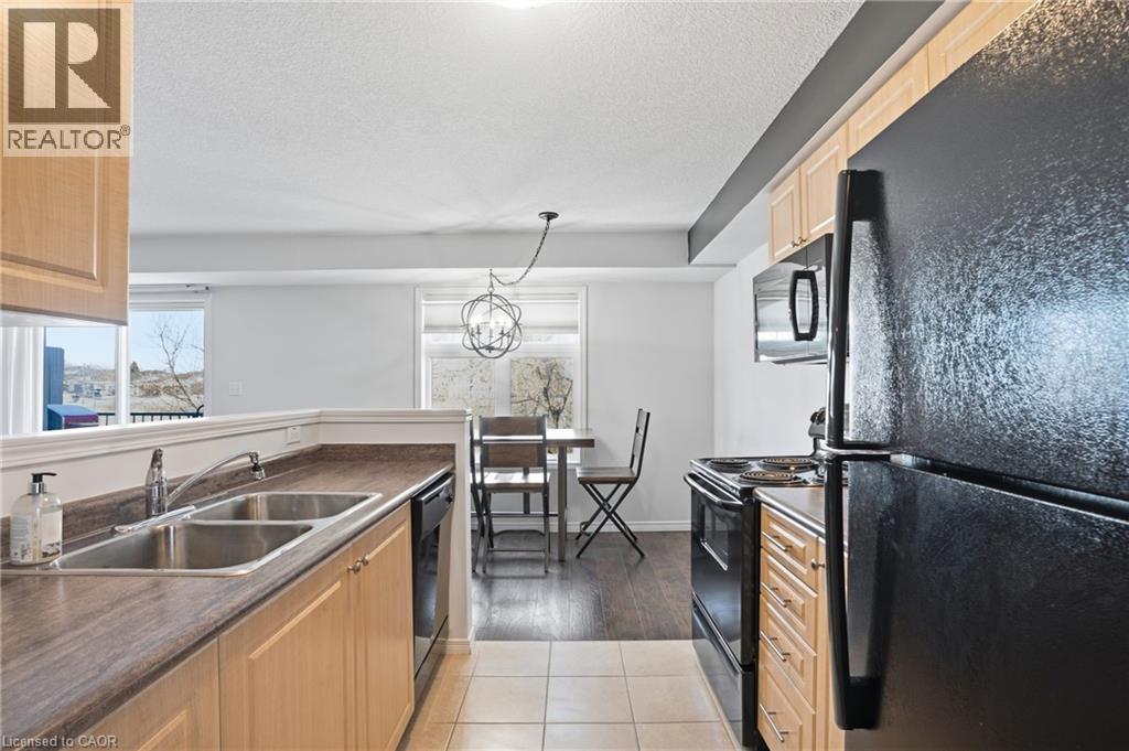 A kitchen with a black refrigerator and wooden cabinets.