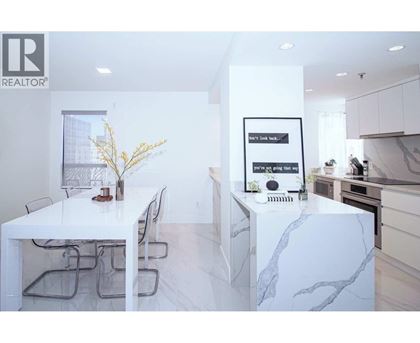 A white dining table with chairs and a framed picture on the wall.