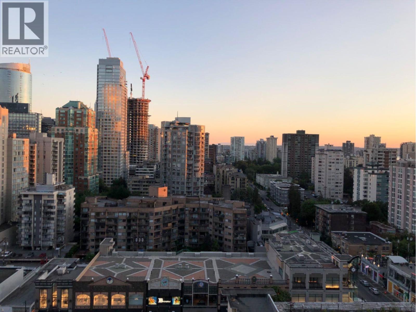 A cityscape with a large building under construction in the foreground.