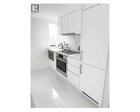A white kitchen with a sink and a window.