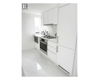 A white kitchen with a sink and a window.
