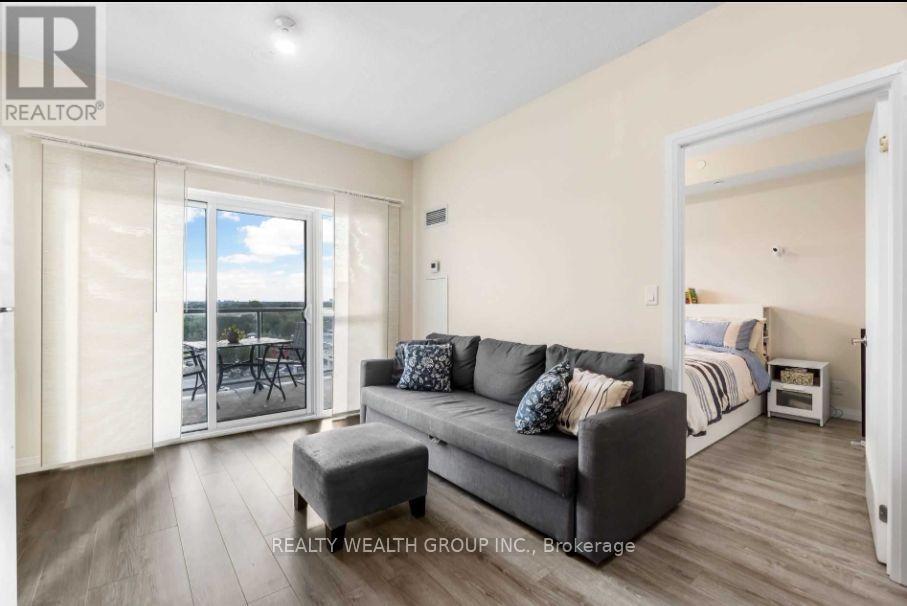 A living room with a grey couch and a wooden floor.