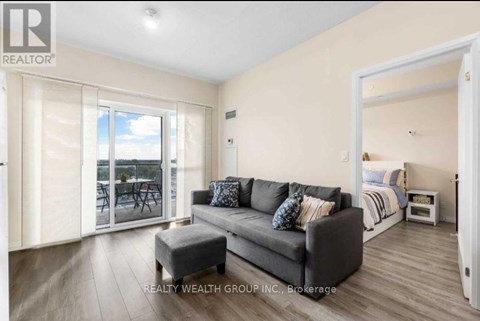 A living room with a grey couch and a wooden floor.