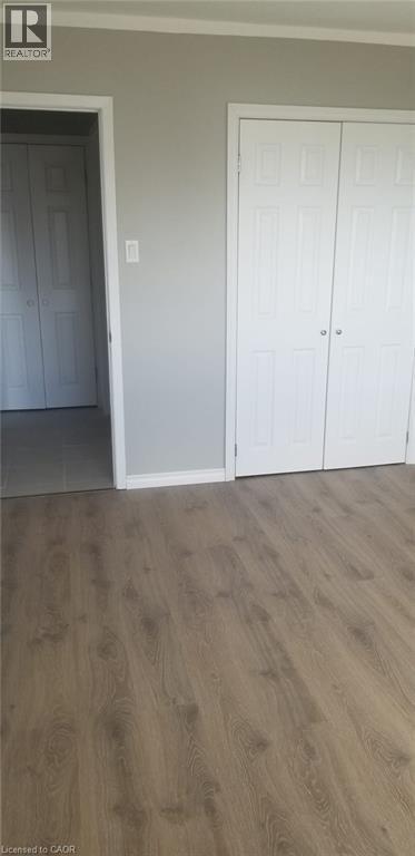 A room with a white door and a wooden floor.