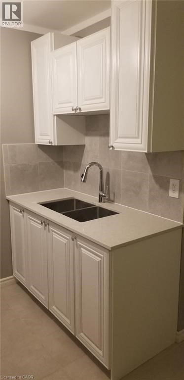 A kitchen with white cabinets and a sink.