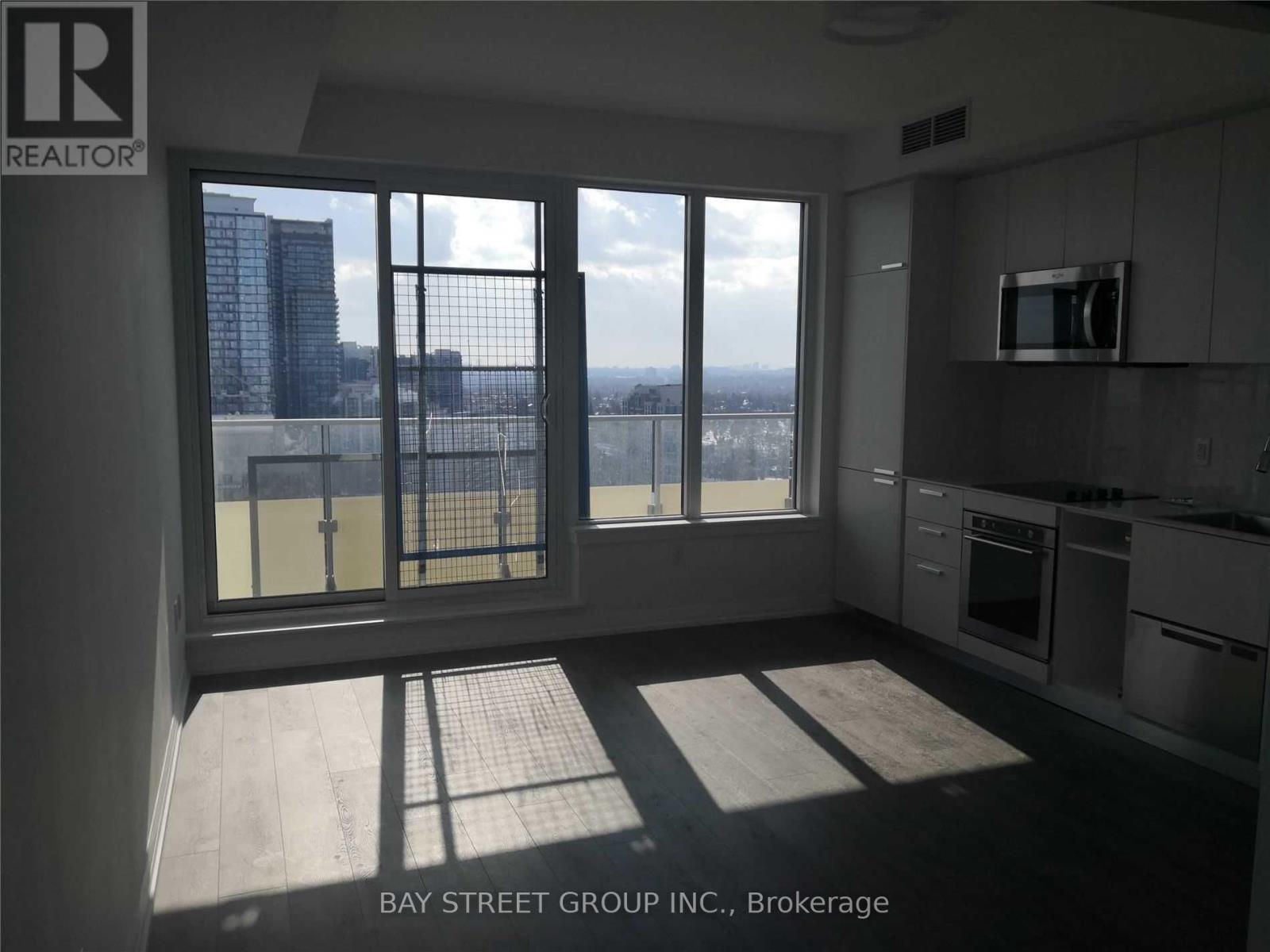 A kitchen with a view of the city through the windows.