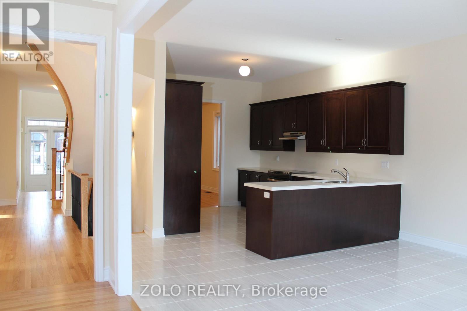 A kitchen with dark brown cabinets and a white countertop.