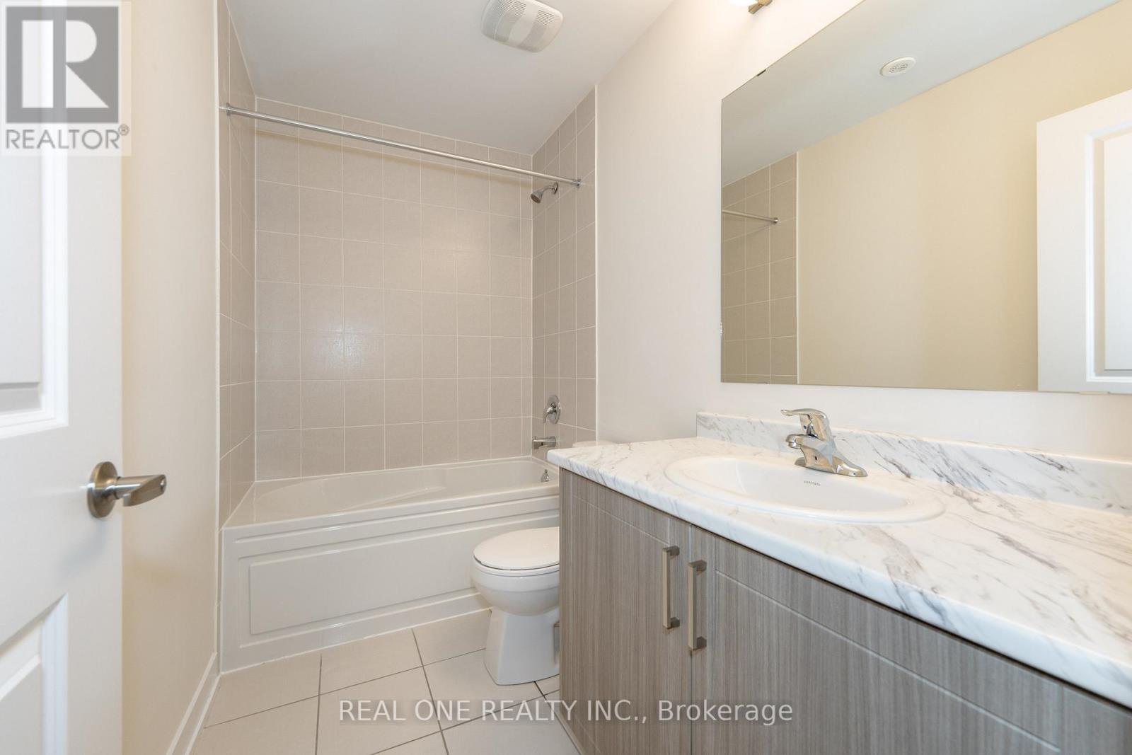 A bathroom with a marble countertop and a walk-in shower.