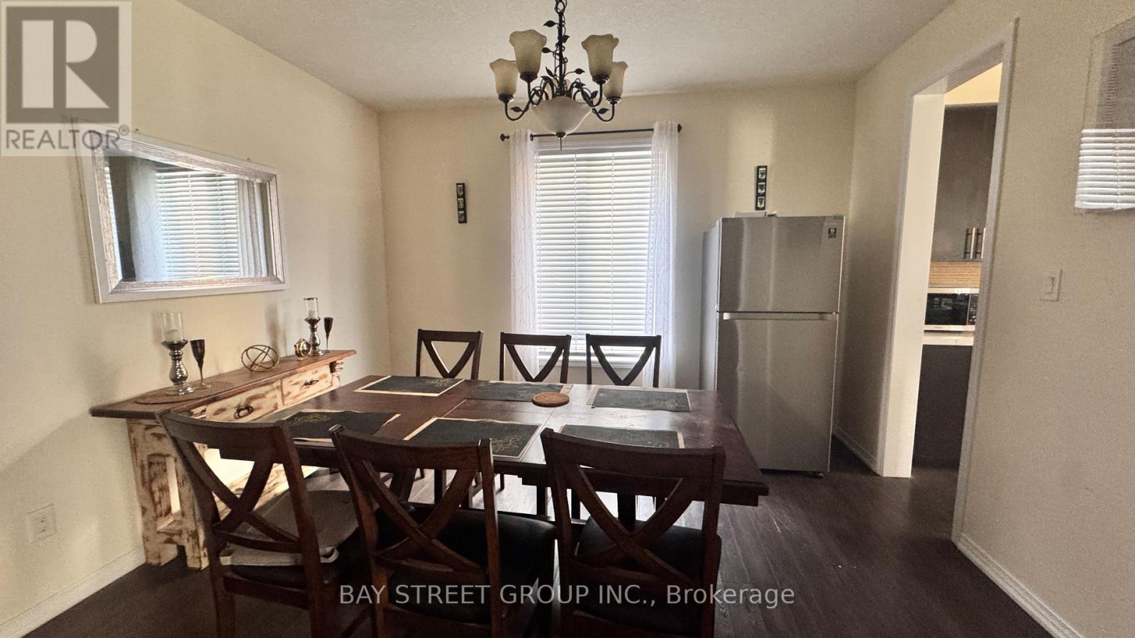 A dining room with a wooden table and chairs.