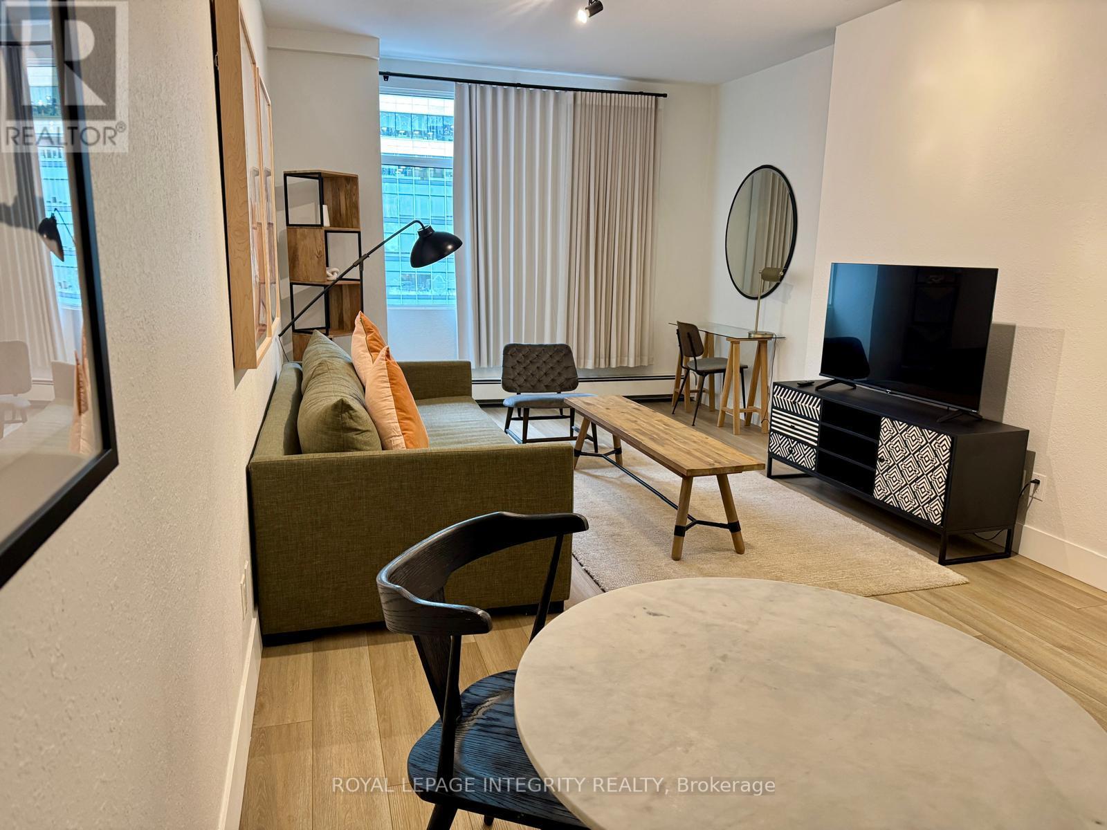 A living room with a couch, chair, and television.