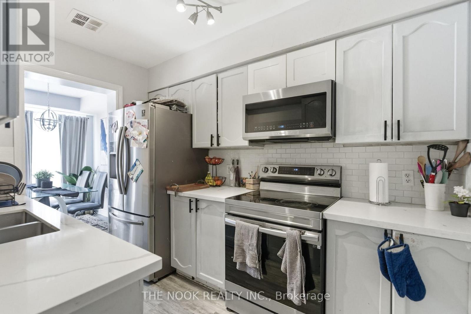 A white kitchen with a stove top oven and microwave.