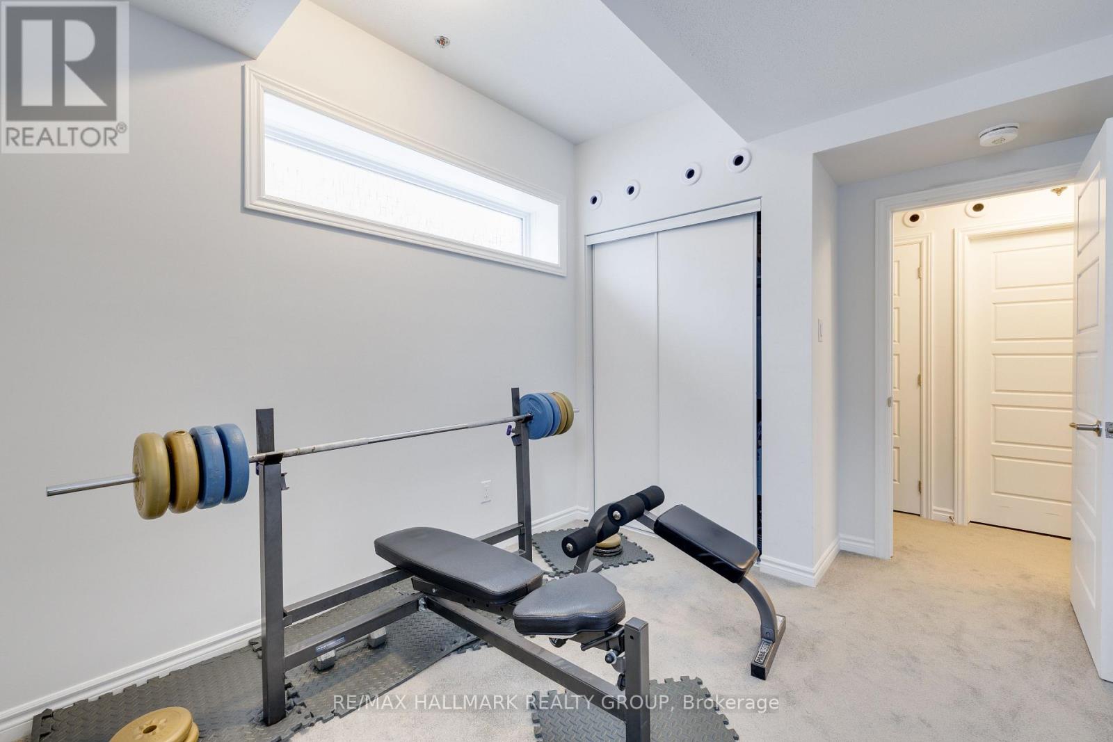 A home gym with a bench, weights, and a barbell.
