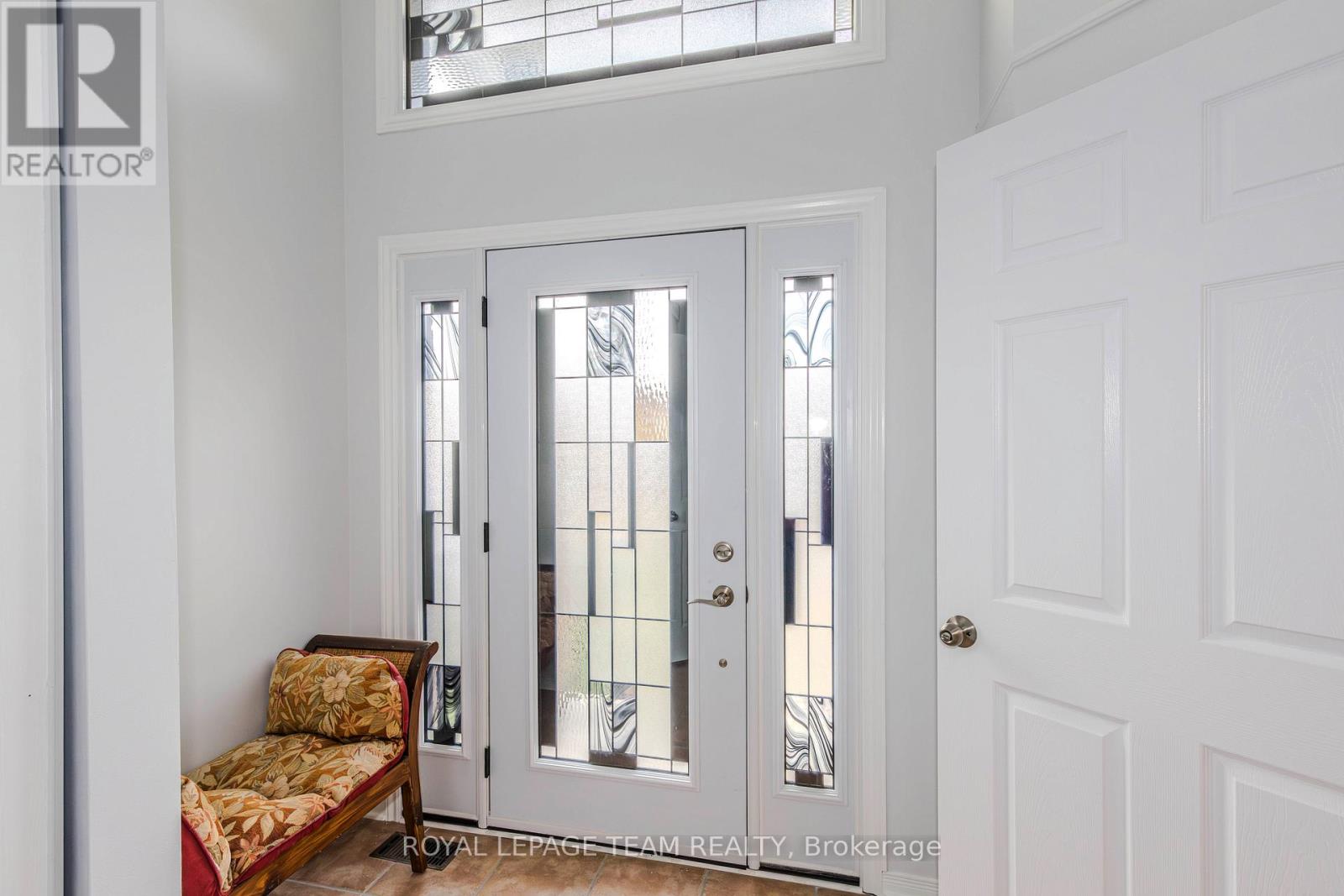 A white door with a glass panel and a wooden bench with a cushion on it.