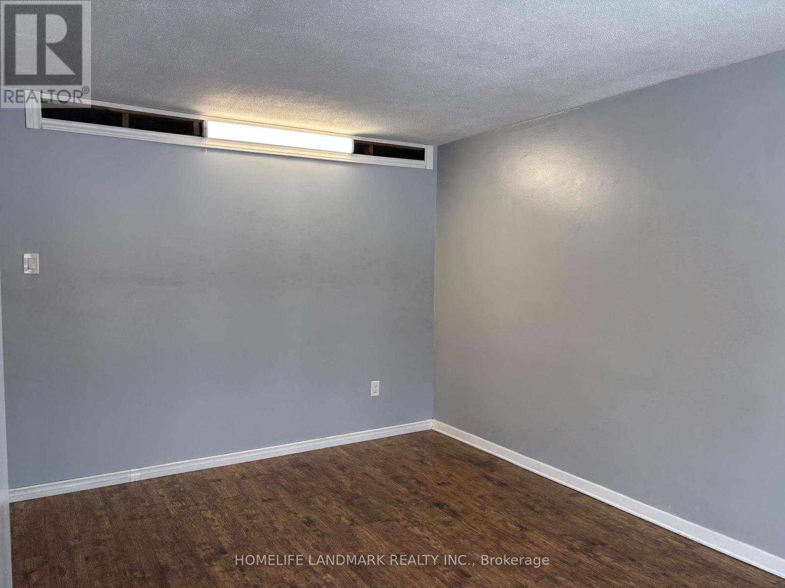 A bedroom with a bed, nightstand, and a dresser with a mirror.