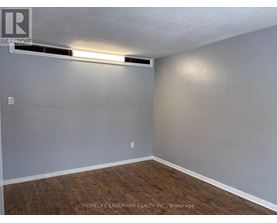 A bedroom with a bed, nightstand, and a dresser with a mirror.