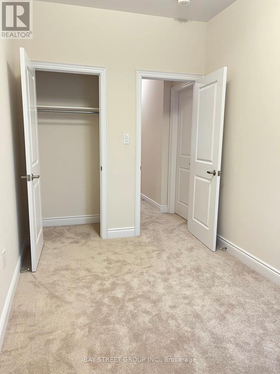 A realtor photo of a bedroom with two doors and carpeted floor.