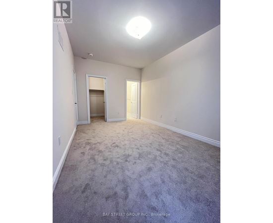 A spacious room with a carpeted floor and white walls.