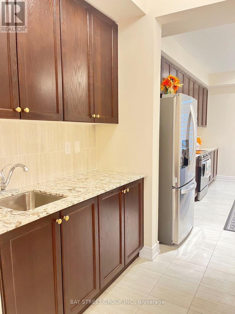 Brown cabinets with a sink and refrigerator in a kitchen.