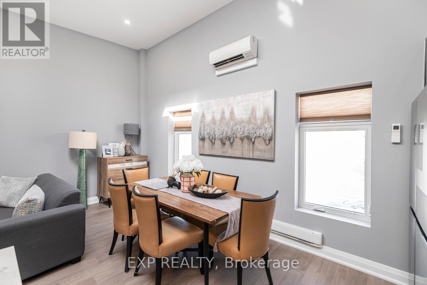 A dining room with a table set for four and a couch.