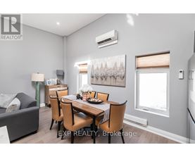 A dining room with a table set for four and a couch.