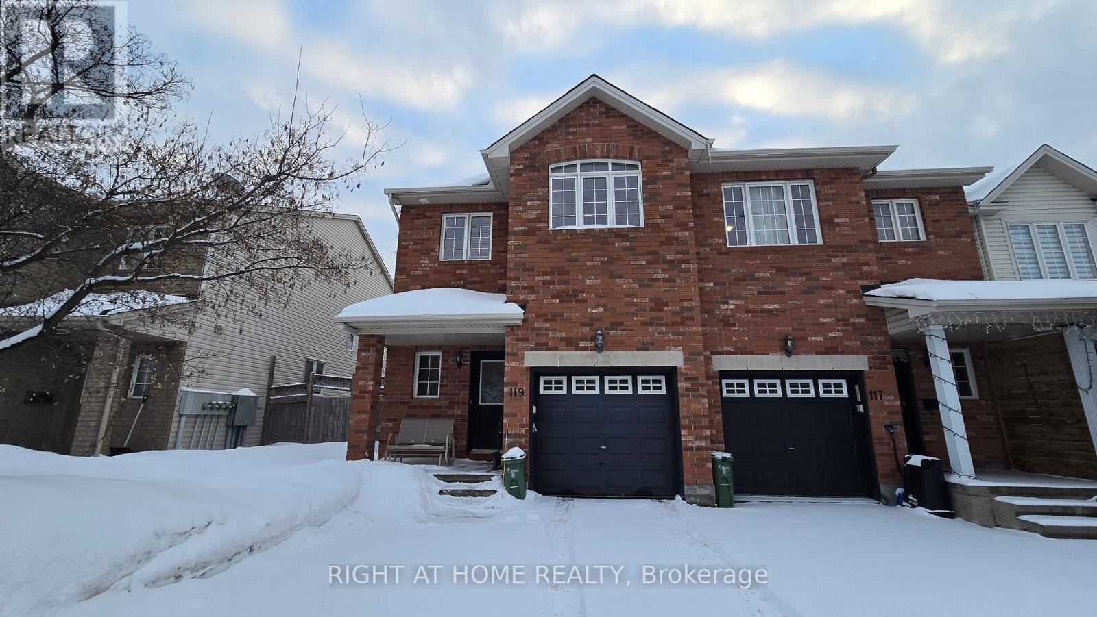 A brick house with a snow-covered front yard.