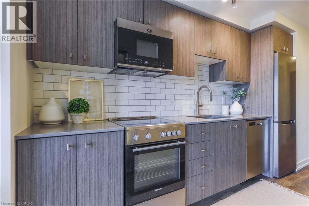 A modern kitchen with wooden cabinets and a black microwave above the stove.