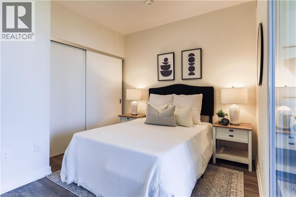 A bedroom with a bed, nightstand, and two wall lamps.