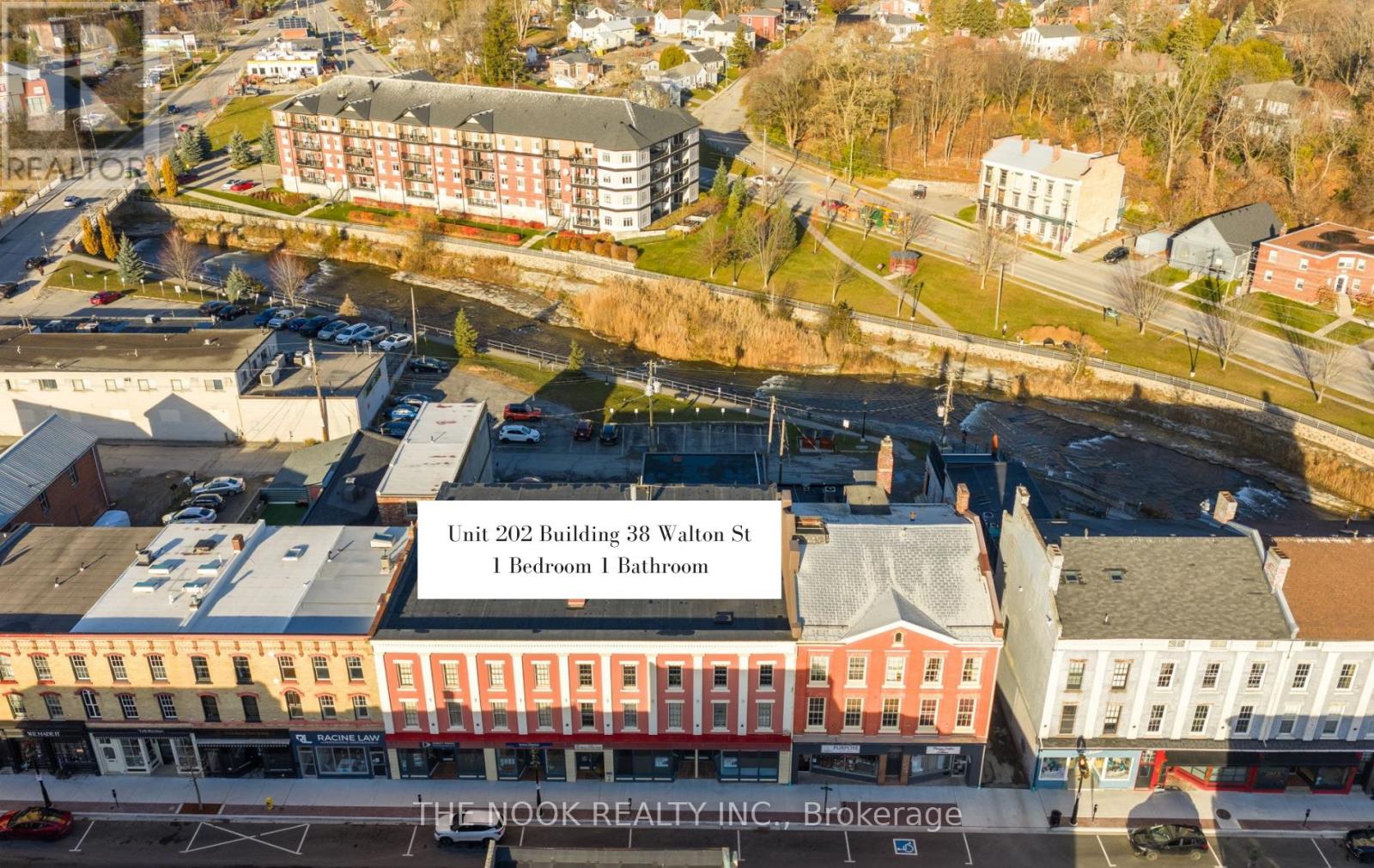 An aerial view of a town with a building that has a sign stating it has 1 bedroom and 1 bathroom.