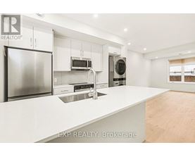 A modern kitchen with white countertops and stainless steel appliances.