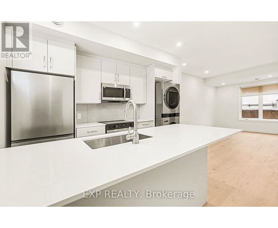 A modern kitchen with white countertops and stainless steel appliances.