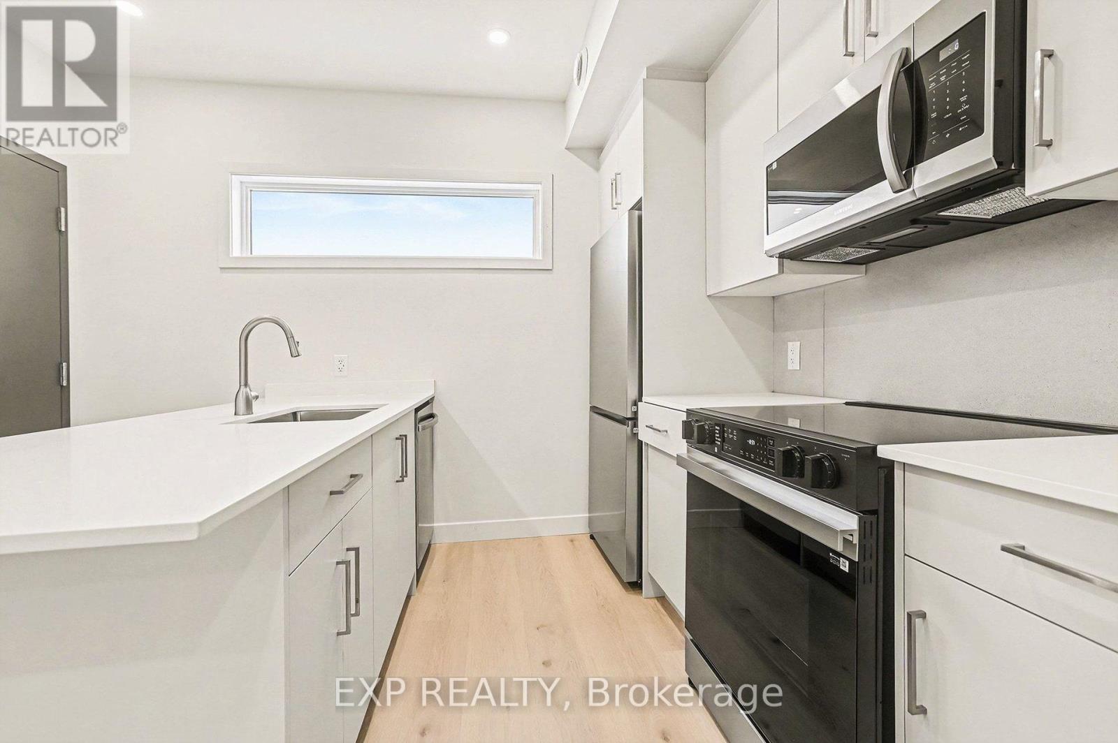 A modern kitchen with white cabinets and appliances.