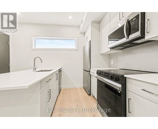 A modern kitchen with white cabinets and appliances.