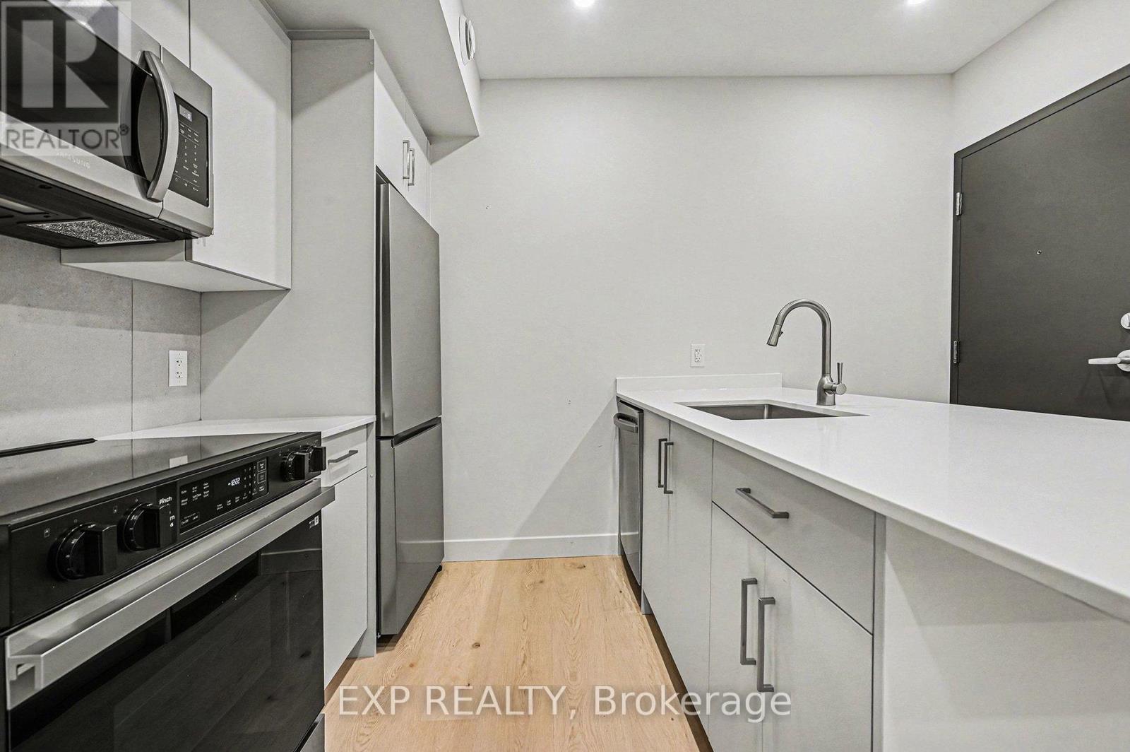 A modern kitchen with white cabinets and stainless steel appliances.