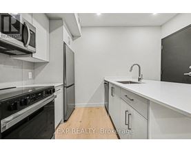 A modern kitchen with white cabinets and stainless steel appliances.