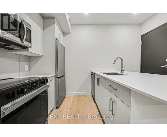 A modern kitchen with white cabinets and stainless steel appliances.