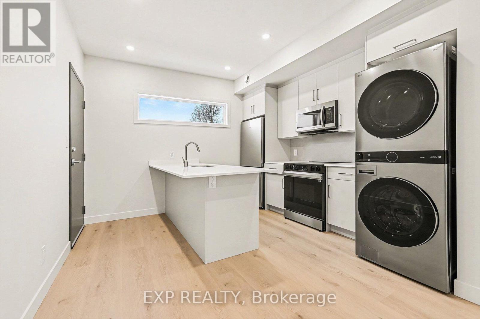 A kitchen with a sink, oven, and microwave.