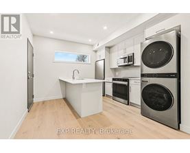 A kitchen with a sink, oven, and microwave.