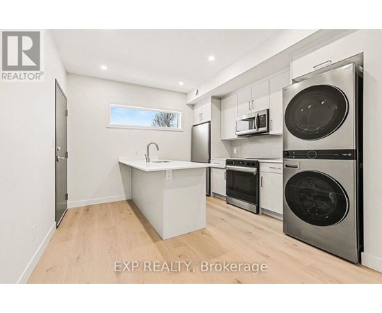 A kitchen with a sink, oven, and microwave.