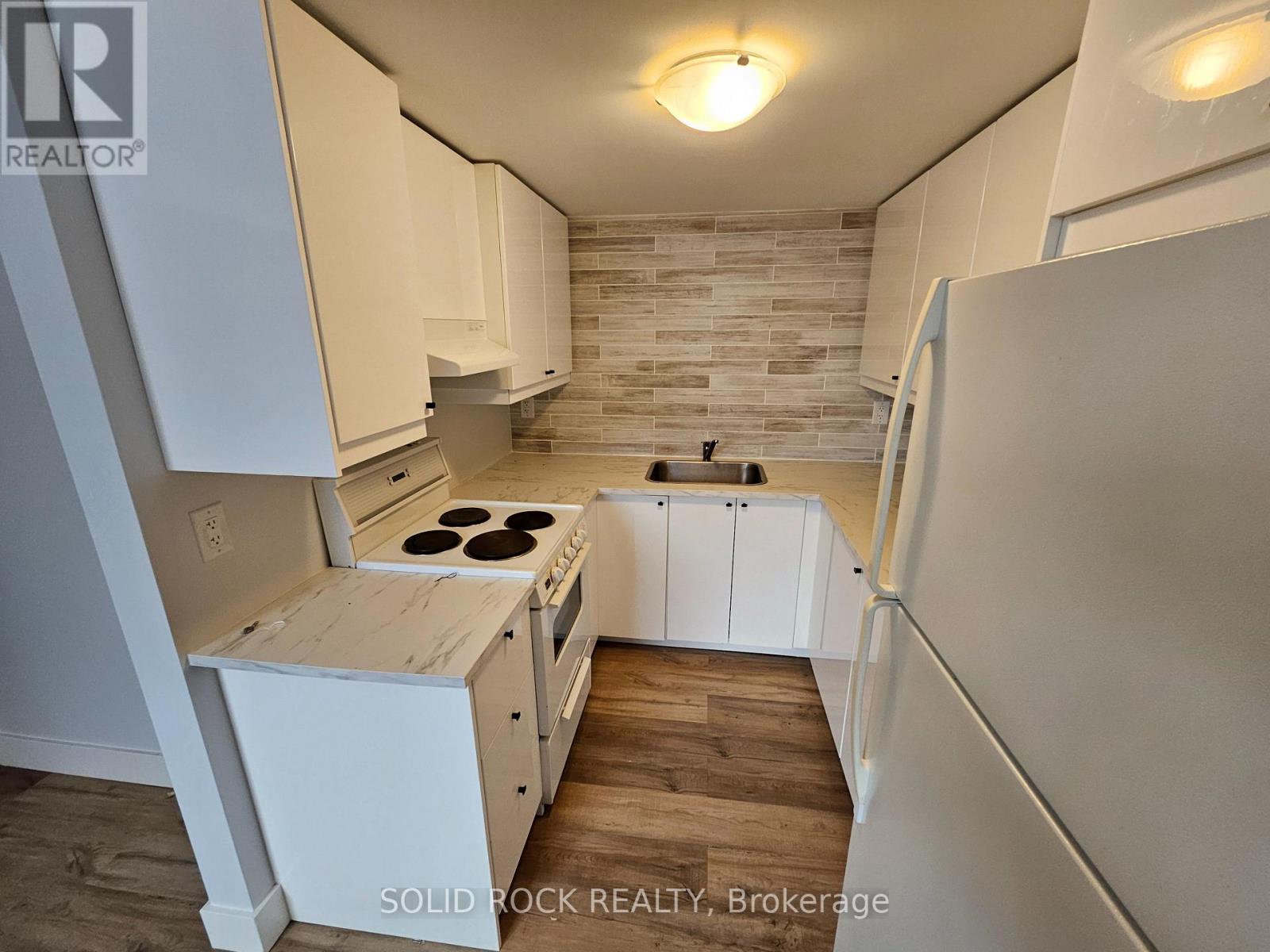 A kitchen with white cabinets and a wooden island.