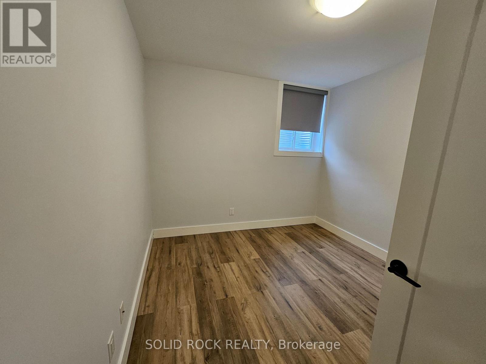 A room with wooden flooring and a window.