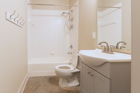 A white toilet sits next to a white sink in a bathroom.