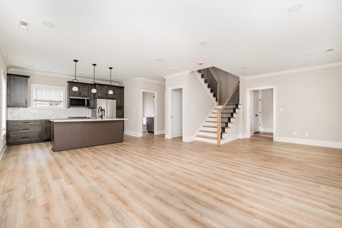 A spacious living room with a staircase leading to the upper floor.